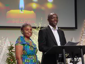 Pastor Gatera and his wife, Appoline, standing at a speaker podium.