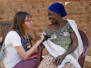 Kathryn Mahoney shakes hands with Zeinabou, a forcibly displaced woman in Burkina Faso.