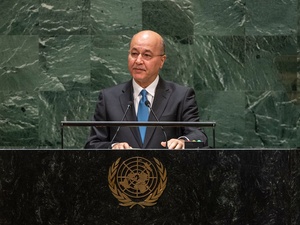 Barham Salih, wearing a suit, speaks at a podium bearing the United Nations emblem