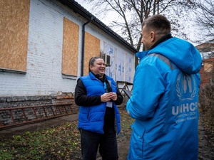 People are standing in front of the damaged building