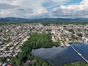 An aerial view of a town and mangroves clustered around an inlet.