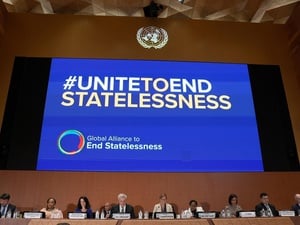 A large screen, over a panel of people sitting, reads "#UNITEDTOENDSTATELESSNESS Global Alliance to End Statelessness"