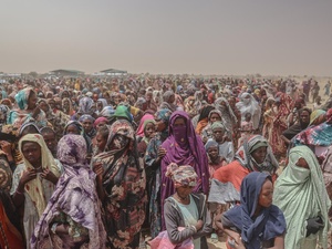 A huge crowd of refugees wait for food.