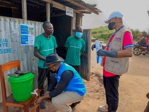 UNHCR staff inspect a chlorinated handwashing station