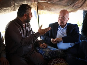 UN High Commissioner for Refugees Barham Salih talks with a displaced man in a shelter in Al-Hijra Camp.
