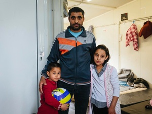 An Afghan asylum-seeker stands with two of his children at a reception centre in Fylakio, Greece, in February 2020.