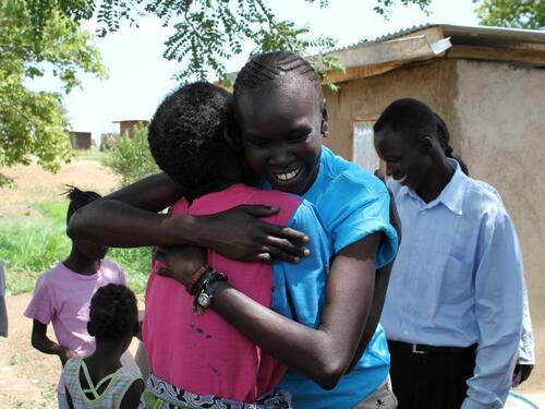 Supermodel, former refugee and UNHCR Refugee Advocate, Alek Wek greets a woman in a returnee community in Juba, South Sudan. UNHCR/B.Sokol/July 9, 2012