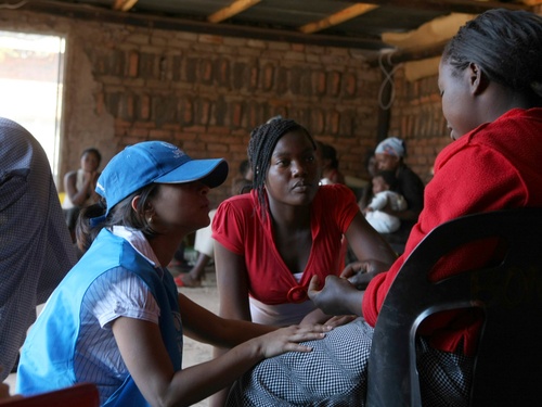 UNHCR staff with women and children in a protection shelter