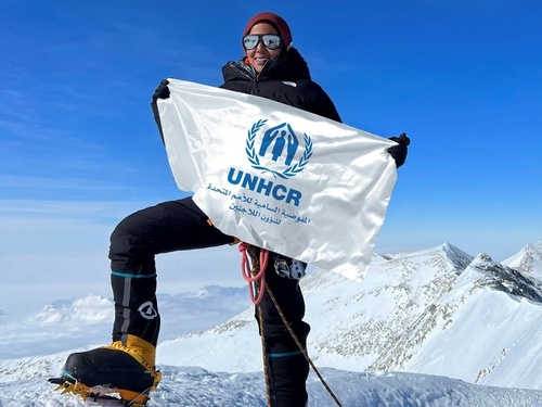 Sheikha Asma Al Thani holding a UNHCR banner in the snow