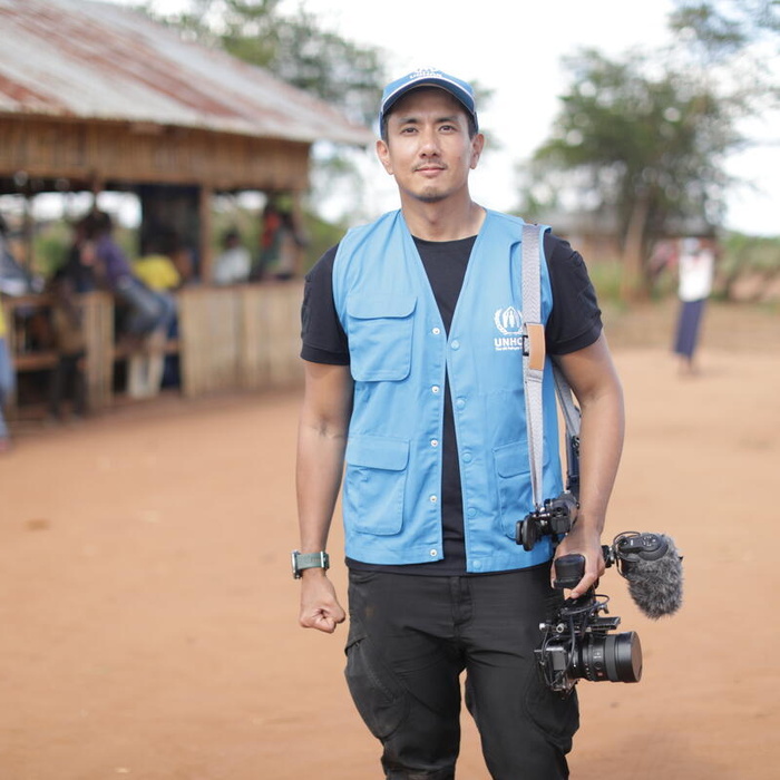 Wannasingh Presertkul stands holding a video camera at his side