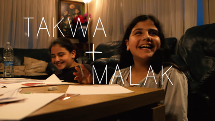 Twin girls laughing while doing their homework.