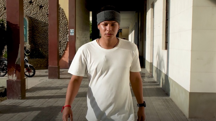 A young man walking on the sidewalk