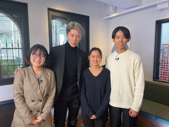 MIYAVI poses for a photo with three other people indoors.