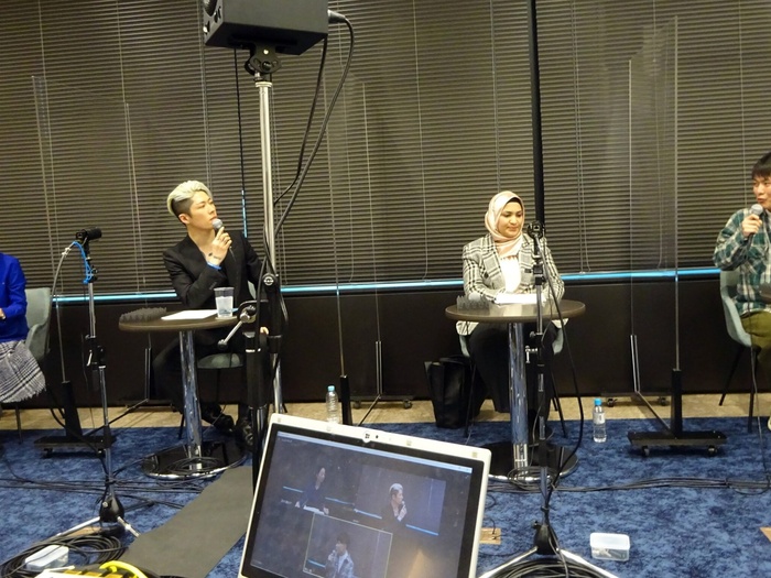 MIYAVI pictured with a microphone at a table, participating in an online event with three other people.
