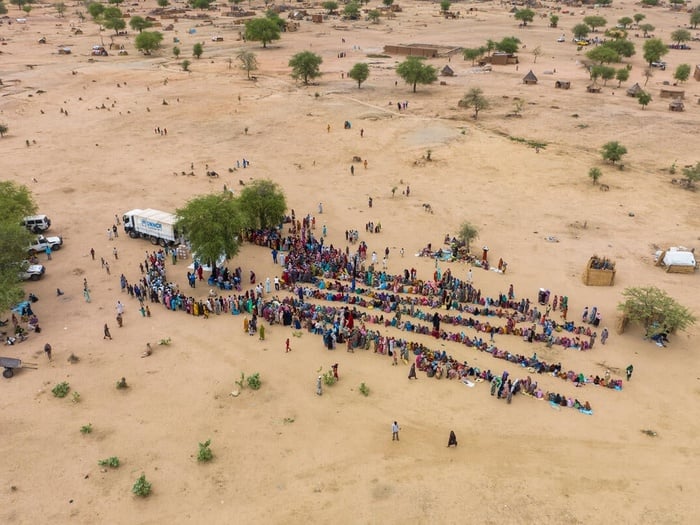 Aerial view of Sudanese refugees standing in line to receive relief item kits from UNHCR.