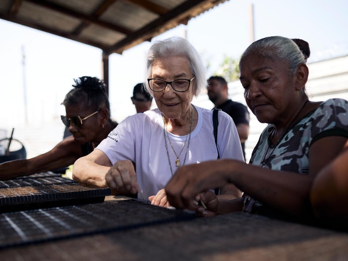 Sister Rosita Milesi sows seeds with refugee Mariela Josefina Astudillo
