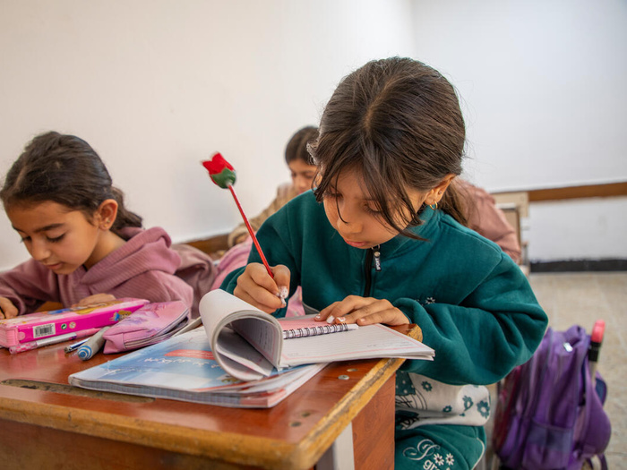 Two Syrian refugee students writing in their notebooks in Erbil, Iraq. 