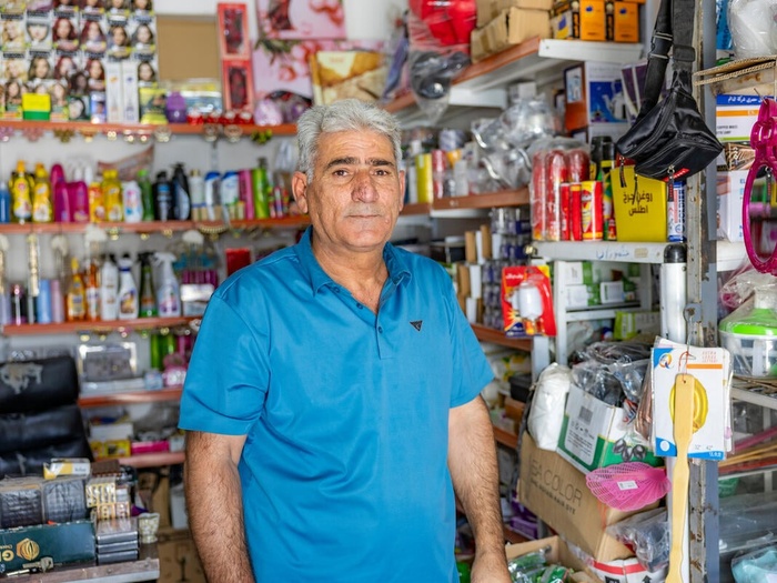 A Syrian man pictured in the crowded shop he runs.