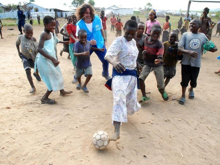 Osvaldo Laport plays football with Congolese children on the dusty ground.