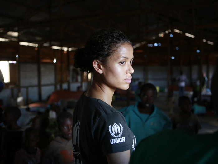  Gugu Mbatha-Raw stands in a room, wearing a UNHCR black t-shirt.