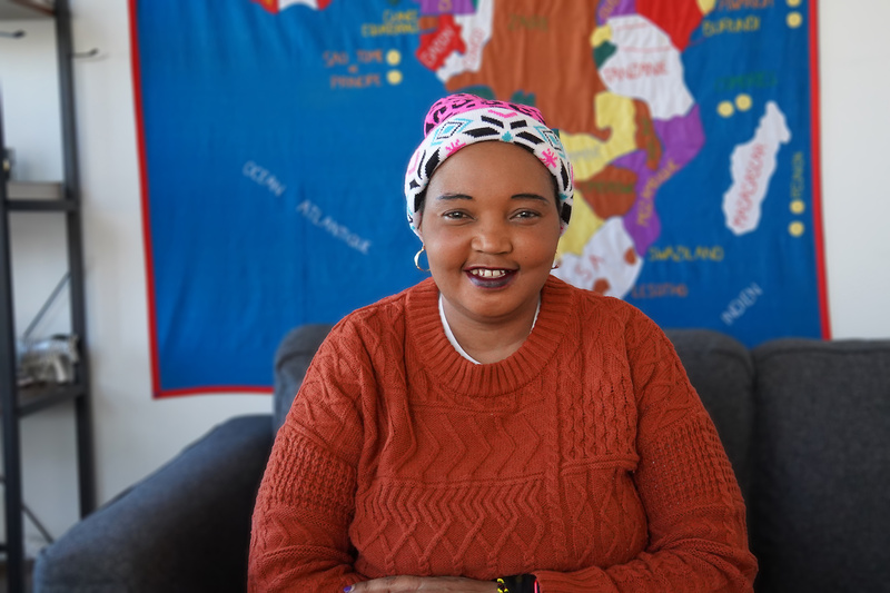 Aline, a refugee from the Democratic Republic of the Congo sitting down.