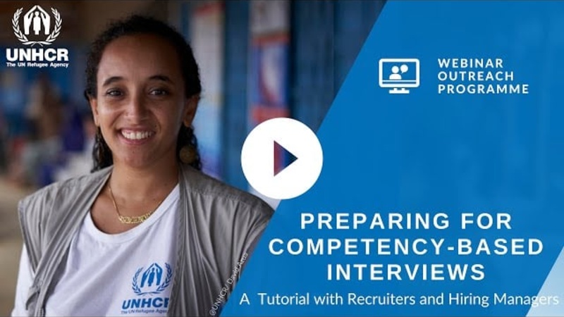A UNHCR staff member smiling at the camera
