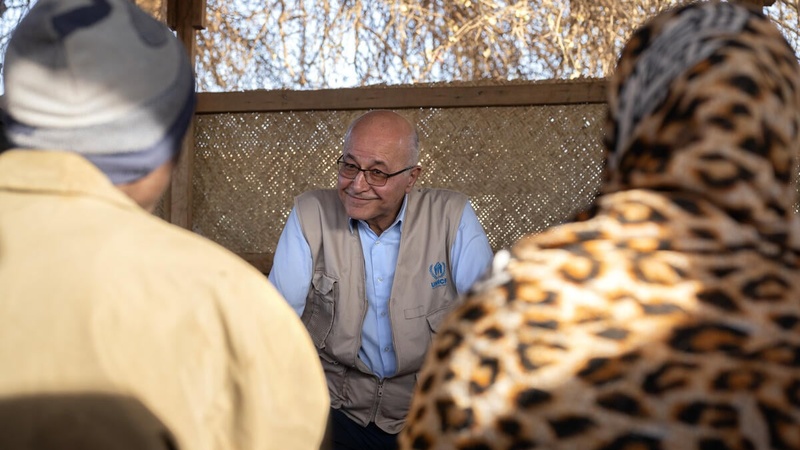 Barham Salih pictured speaking with two people whose backs are to the camera.