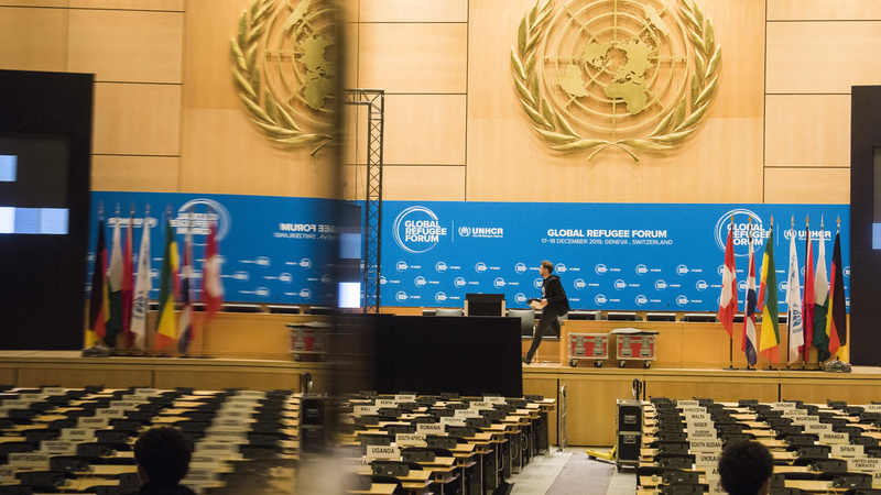 A conference room with a stage and rows of seats.