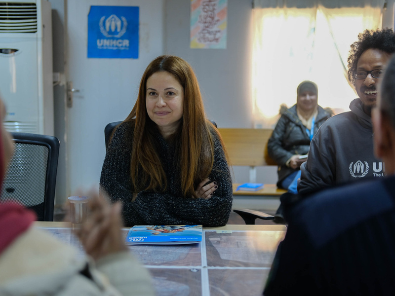 Raya Abirached sits at a table next to UNHCR staff members