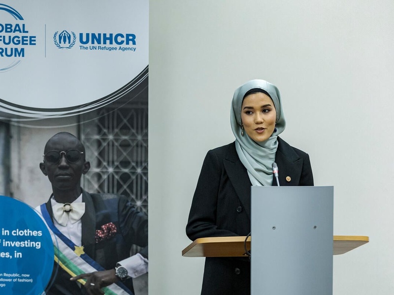 Masomah speaks into a microphone on the stage of an event. 