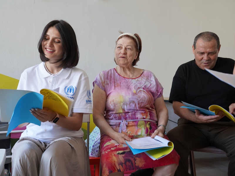 Valentina Naforniță smiling and reading lyrics on printed paper