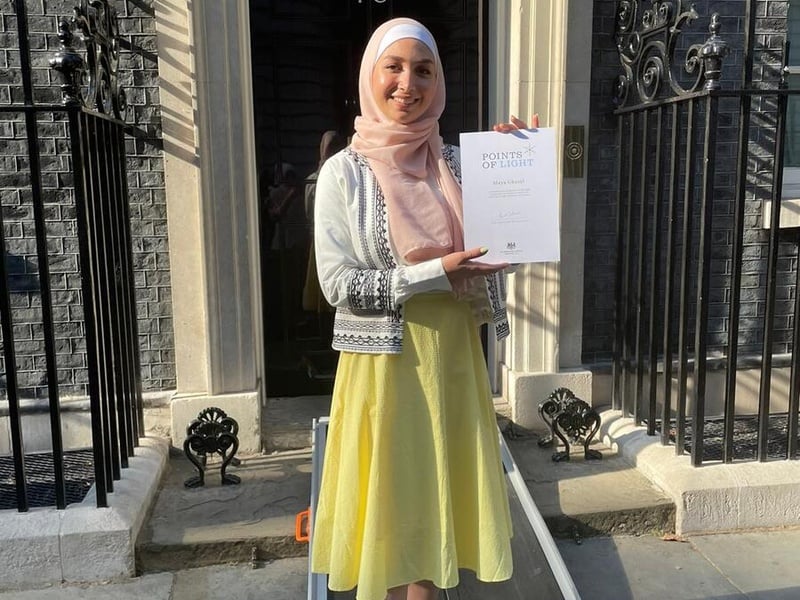 Maya Ghazal holding her "Point of Light" Award