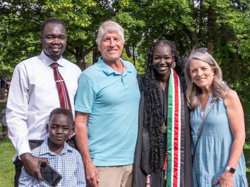 Mary Maker poses with friends and family, wearing her graduation robe.