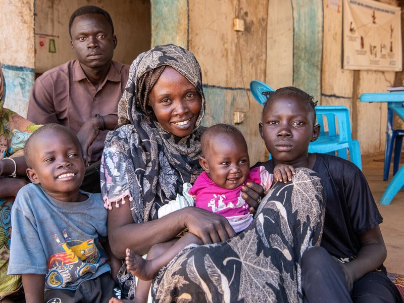 Sudanese refugee Intisar, 27, poses for a photograph with her three children