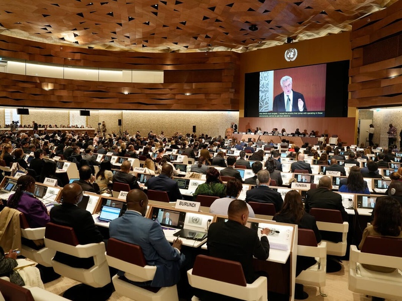 Government representatives watch the High Commissioner speak on a screen inside the Palais des Nations.
