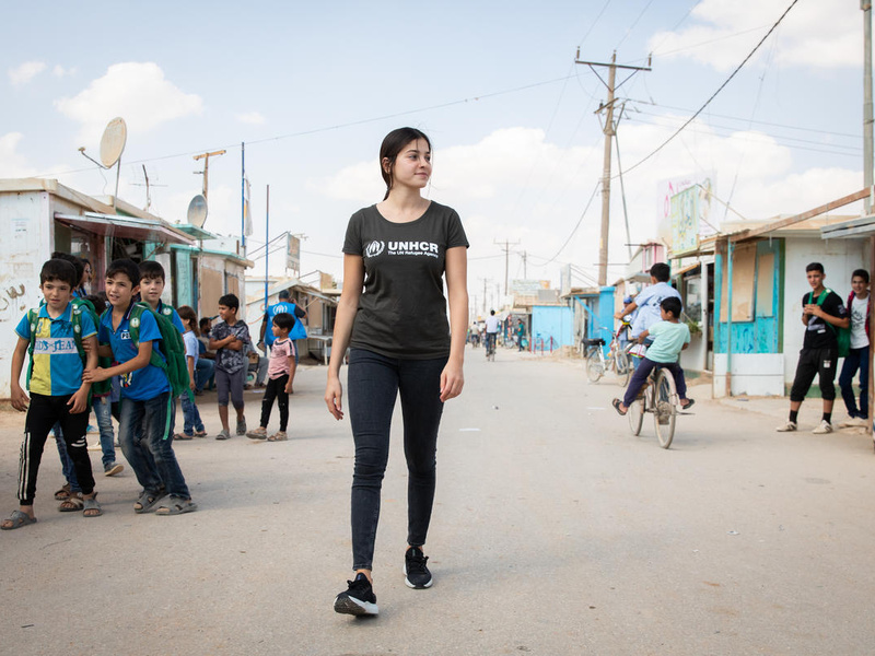 UNHCR Goodwill Ambassador Yusra Mardini walks the main market street, the Champs Elysees, in the Zaatari refugee camp in Jordan. 