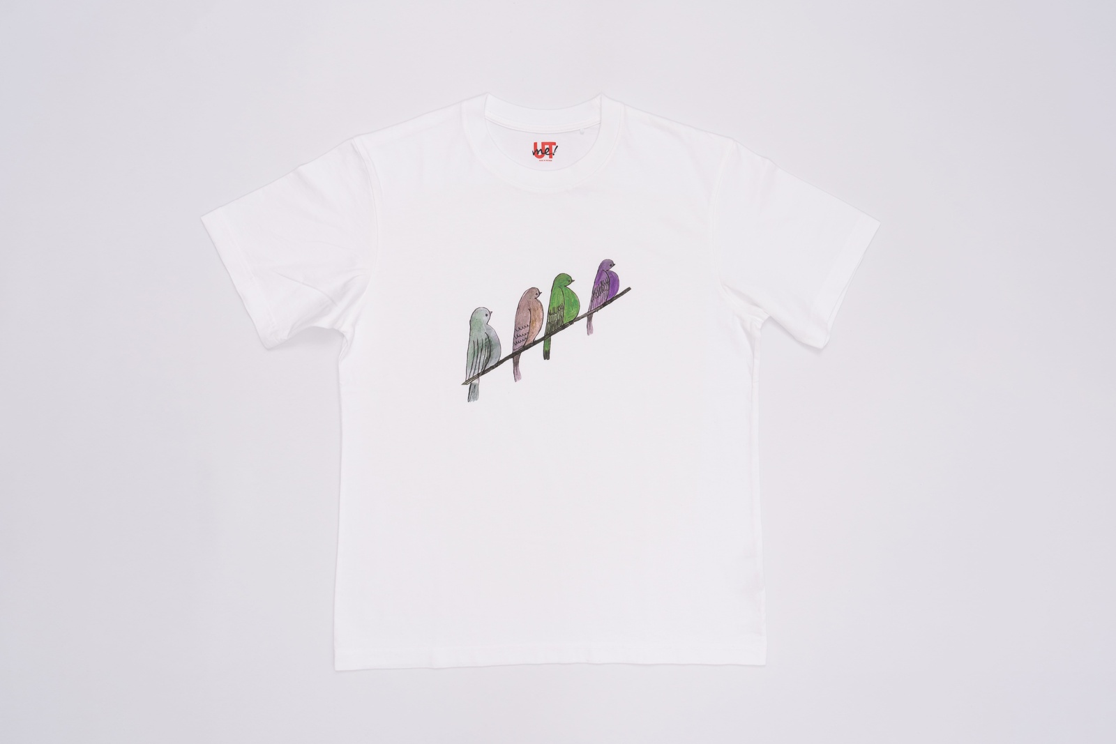 A white t-shirt with an illustration of four birds standing next to each other on a thread.