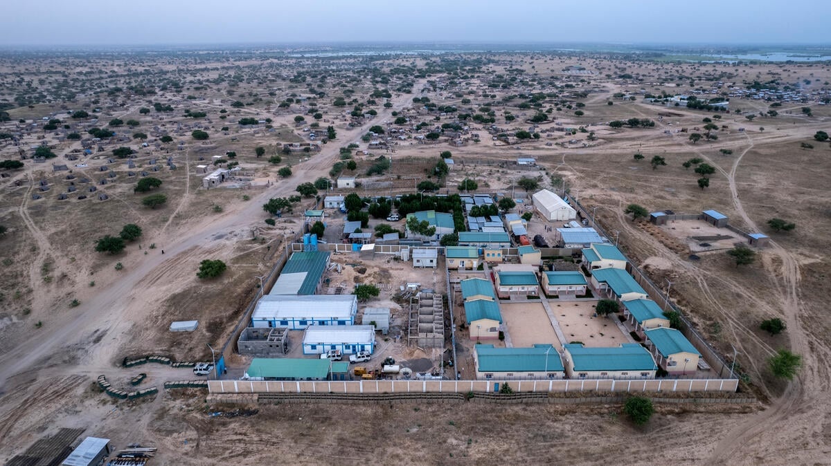 Aerial view of a small settlement in a very flat area with sparse trees.
