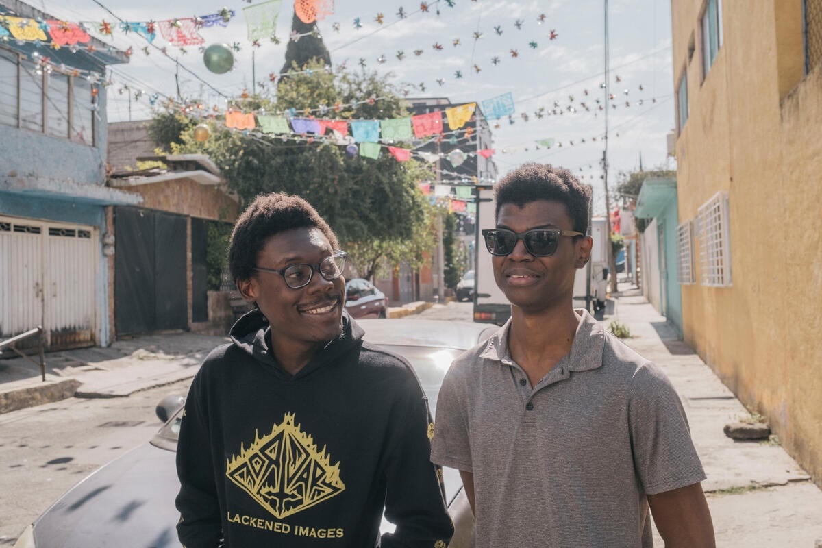 Two men walk down a street together in Mexico City.