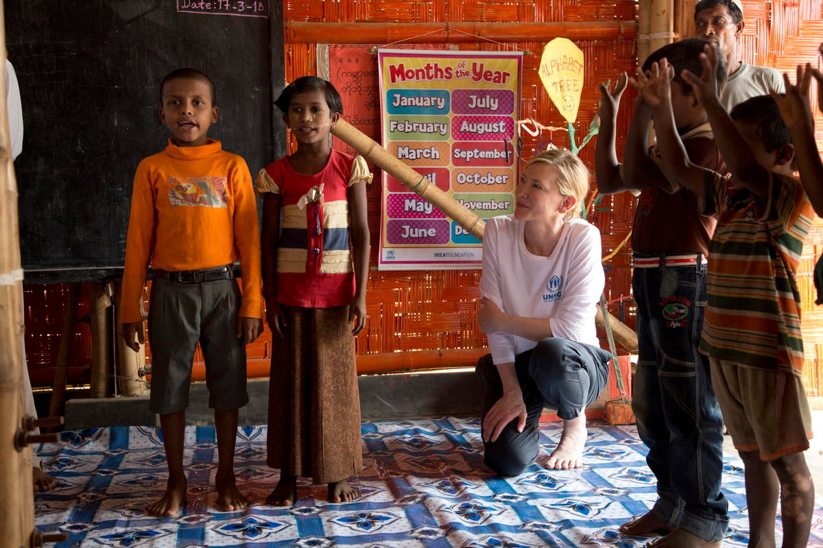 Four children perform while Cate and another adult look on. 
