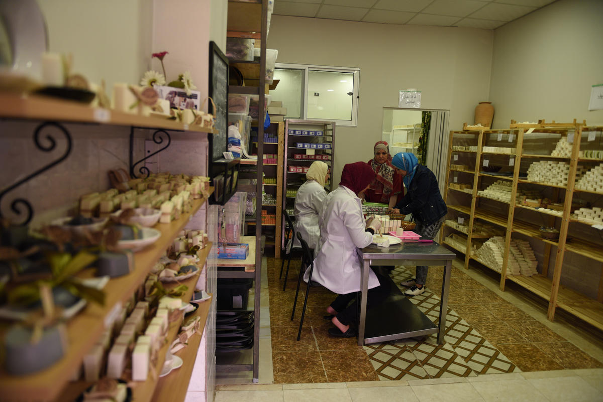 Najwa (rear) and her employees prepare orders at their shop in Zarqa, Jordan.