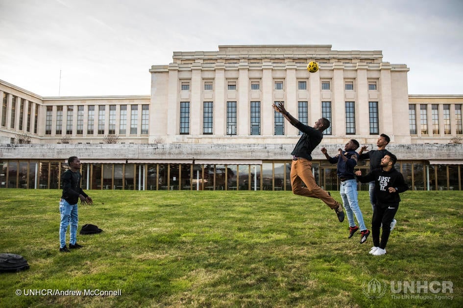 Refugees and asylum-seekers attending events during the Global Refugee Forum play football on the lawn at the Palais des Nations.
