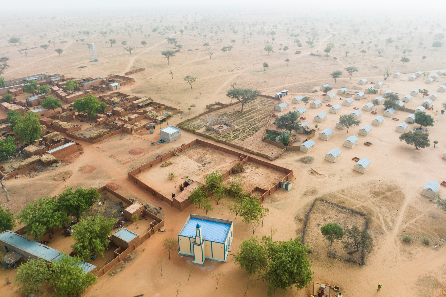 An aerial view of a newly built settlement next to an established one.