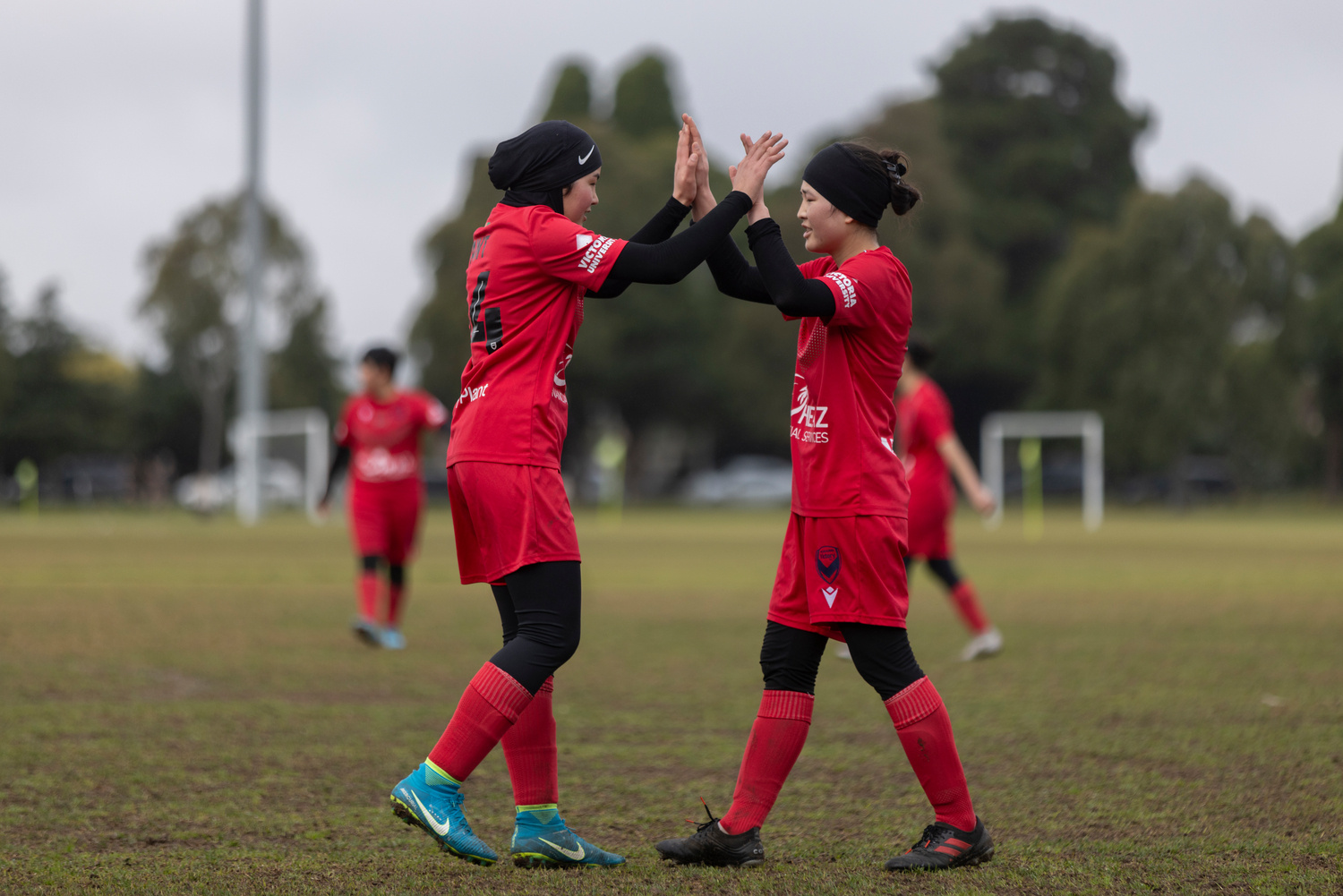 Two women football players high five each other.