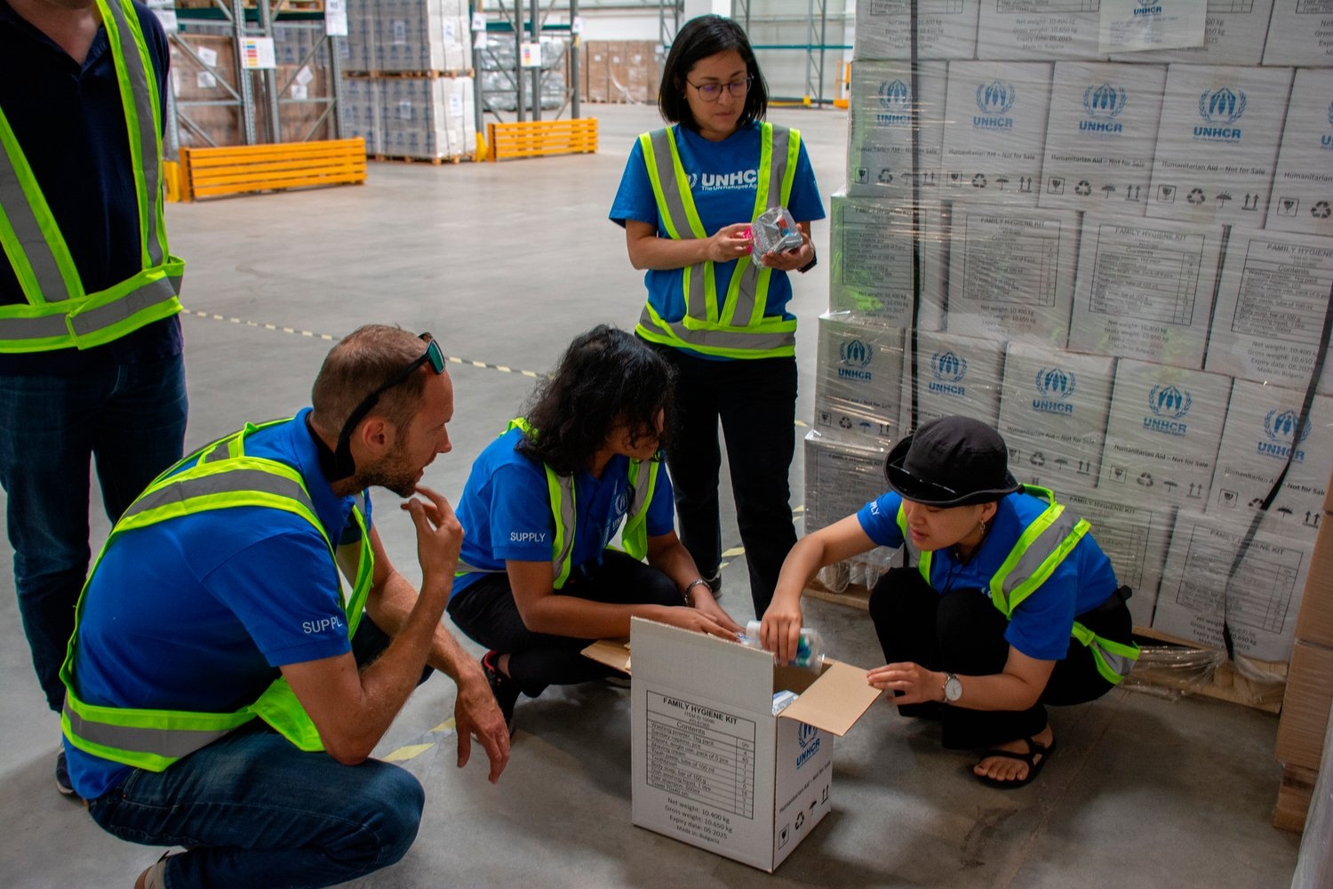 Members of the supply team inspect the contents of a family hygiene kit.