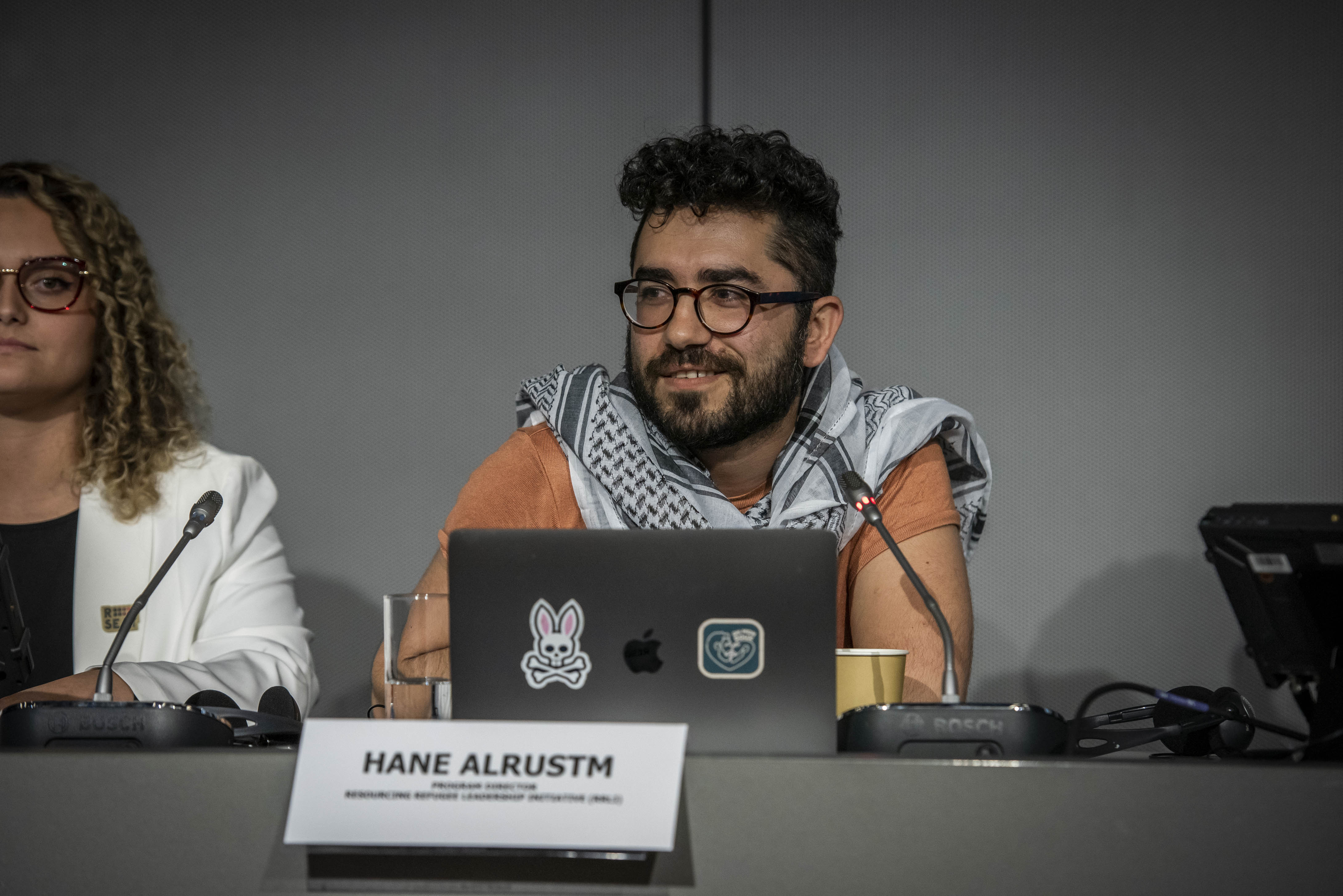 A man sits behind a podium during a panel event