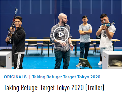 three men and their coach practice air rifle in a gym