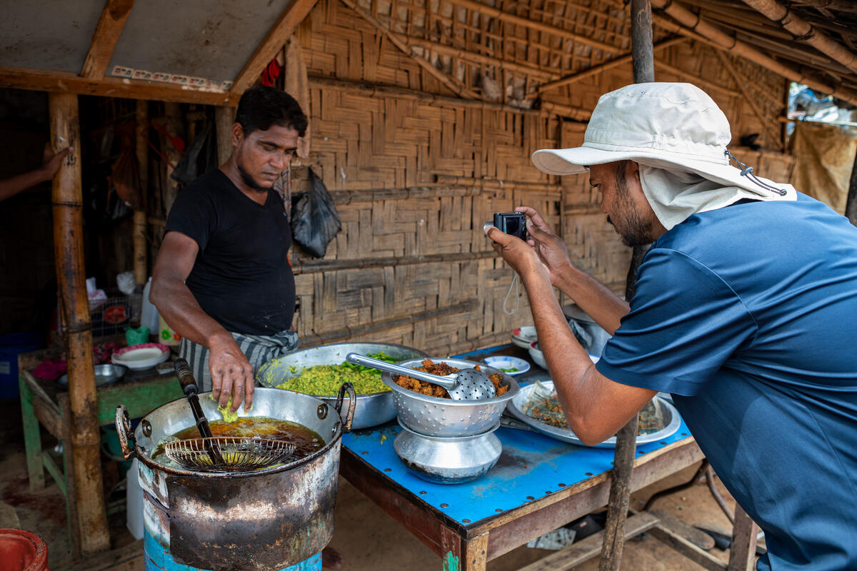 Salim Khan photographs a Rohingya man preparing food.