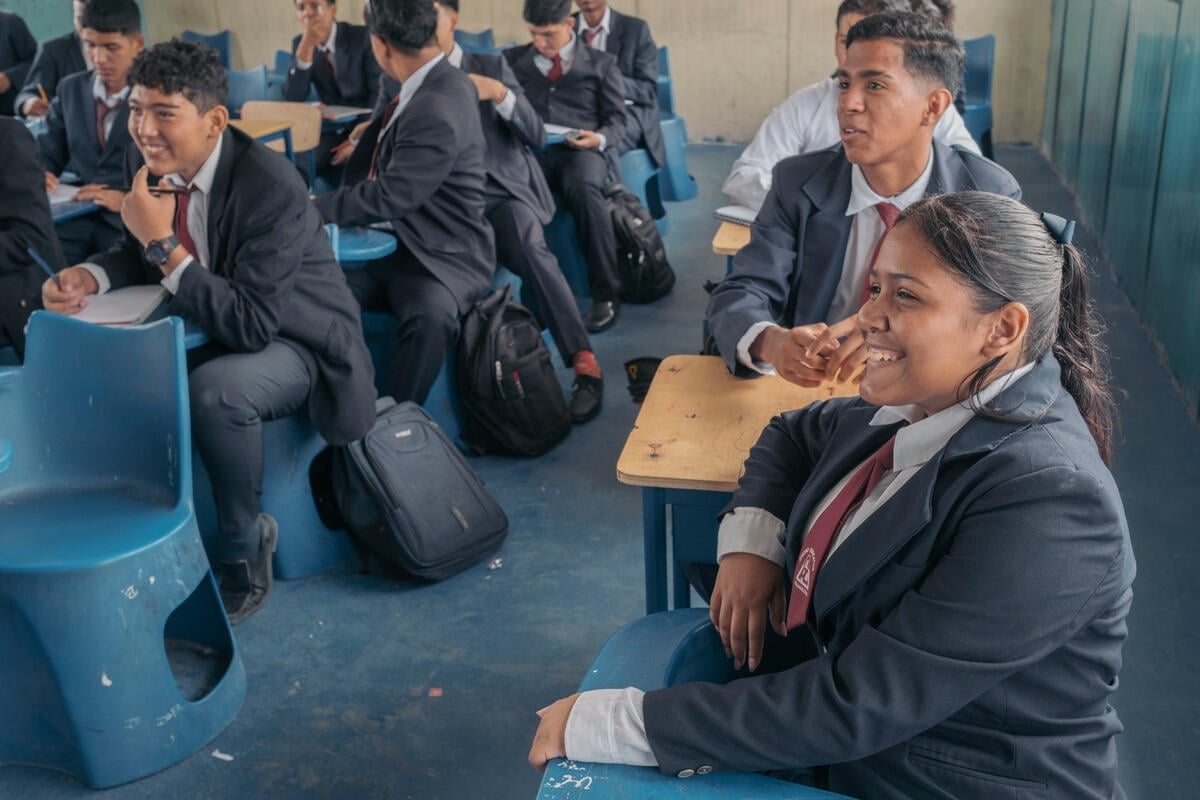 A young woman and her classmates share a laugh in the classroom