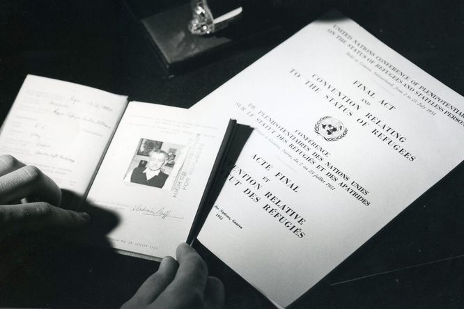 A black and white photo showing travel documents and The Convention Relating to the Status of Refugees.